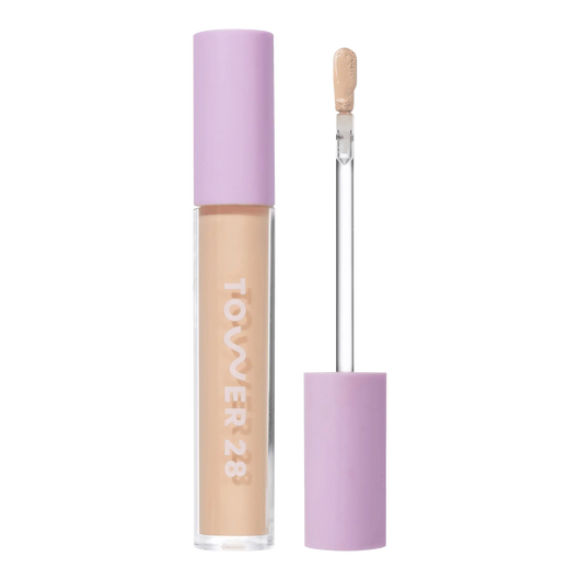 Tower 28 Beauty Swipe Serum Concealer in the shade 6.0 IE, shown with the tube standing upright next to the open applicator wand to reveal the product. [6.0 IE]